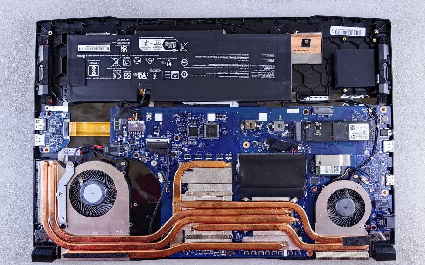 Bên trong laptop khi mở nắp lưng với pin, quạt và ống đồng tản nhiệt cần vệ sinh